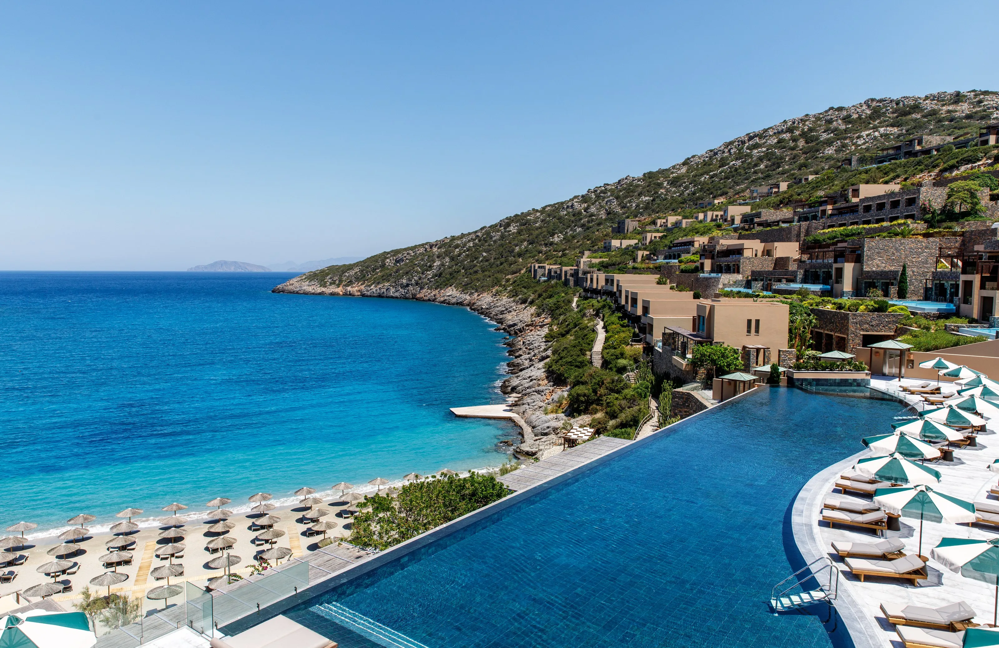 Luftaufnahme von Daios Cove: Hauptpool, Privatstrand und das türkisfarbene Wasser der Bucht von Vathi.